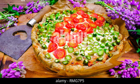 Tarte aux tomates et d'asperges. La nourriture pour les légumes frais et d'herbes. Table d'été Style avec lupins Banque D'Images