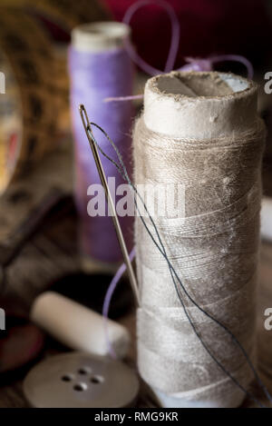 Variuous avec outils de couture, aiguille et du fil, du coton, des boutons sur le vieux bois Banque D'Images