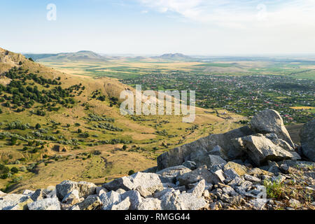 Point de vue sur la vallée d''une télévision avec les villages ruraux entouré de terres agricoles et les collines arides. Vue du coucher de soleil depuis un sommet de montagnes Macin, Roumanie. Banque D'Images