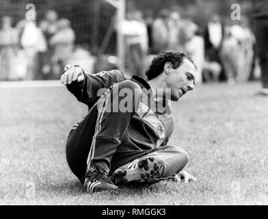 Franz Beckenbauer tombe au sol au cours de la pratique correspond à une partie de la formation de l'international football joueurs dans Erbismuehle pour le match contre le Danemark. Banque D'Images