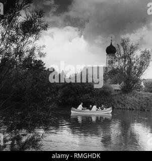 Personnes dans un canot sur la rivière Amper près de Schoengeising avec l'église paroissiale Saint Jean Baptiste, autour de 1980. Banque D'Images