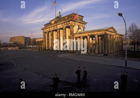 Des milliers de Berlinois de l'Ouest et l'Est de célébrer l'ouverture de la frontière le Mur de Berlin à la porte de Brandebourg. Gardes-frontière de la RDA d'empêcher les gens d'entrer dans la zone réservée à la place en face de la porte de Brandebourg et la Pariser Platz. Banque D'Images