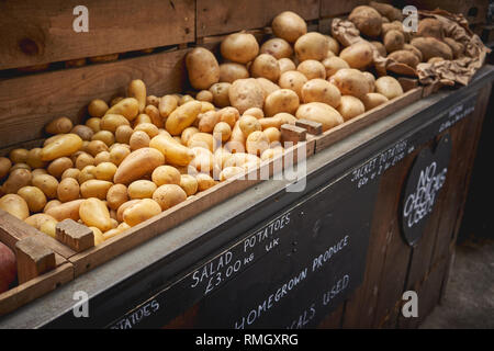Différentes variétés de pommes de terre biologiques en vente sur un étal dans un marché fermier local. Le format paysage. Banque D'Images