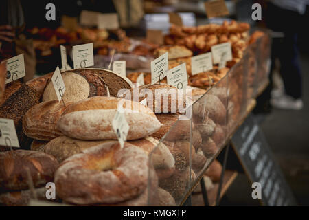 Des piles de brun et blanc bio pains au levain en vente dans un marché fermier local. Le format paysage. Banque D'Images