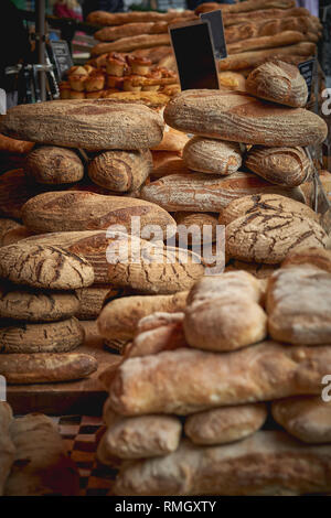 Des piles de brun et blanc bio pains au levain en vente dans un marché fermier local. Le format Portrait. Banque D'Images