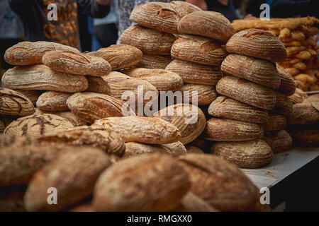 Des piles de brun et blanc bio pains au levain en vente dans un marché fermier local. Le format paysage. Banque D'Images