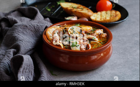 Soupe de crevettes et poulpe près de toasts et spoon Banque D'Images