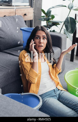 Choqué Woman talking on phone and looking at camera Banque D'Images