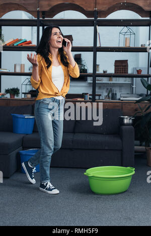 Souligné girl à chemise jaune parlant au téléphone et à la fuite au plafond Banque D'Images