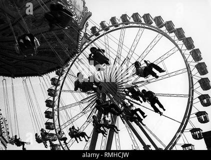 Grande roue et swing ride à l'Oktoberfest de Munich (sans date). Banque D'Images