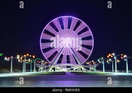 La grande roue sur le boulevard à Bakou, près de la mer Caspienne, tourné dans la soirée sur une longue exposition, avec des effets d'éclairage de couleur. L'Azerbaïdjan. Banque D'Images