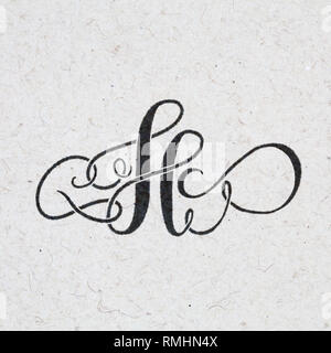 Lettre calligraphique H avec fleurit sur papier kraft Banque D'Images
