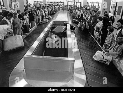 Au Terminal 2 de l'aéroport de Düsseldorf, est arrivé Lohausen passagers attendent leurs bagages à l'aide de tapis roulants . Banque D'Images