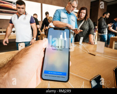 STRASBOURG, FRANCE - Sep 21, 2018 : Apple Store avec les clients achetant admirant le nouveau dernier iPhone Xs - pov au smartphone dans la main de l'homme Banque D'Images