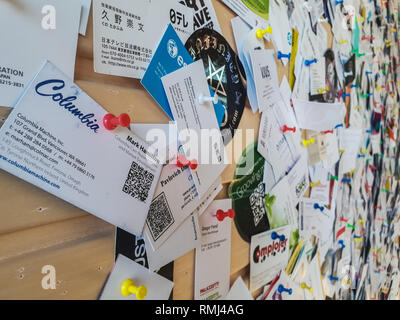 TALLINN, ESTONIE - MAI 2018 - Un grand nombre de cartes d'affaires sont attachées à un mur en bois Banque D'Images