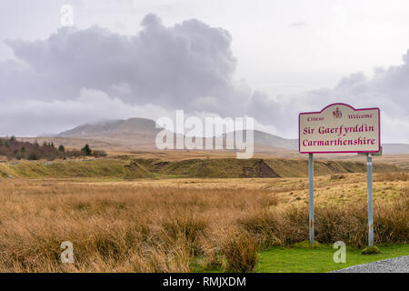 Panneau 'Welcome to Carmarthenshire' avec des cumulonimbus suspendus au-dessus de la chaîne des Black Mountains (fans de Carmarthen) dans les Brecon Beacons, pays de Galles, Royaume-Uni Banque D'Images