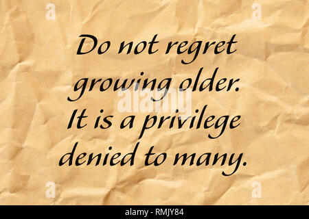 Ne regrette pas de l'âge. C'est un privilège refusé à de nombreux. Le vieillissement positif citer écrit sur papier brun froissé. Banque D'Images