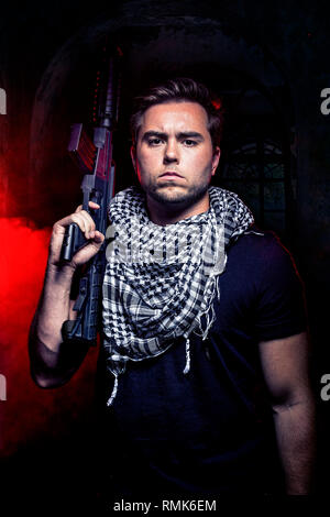 Soldat avec une arme à survivre dans les ruines d'un smoky warzone urbain en feu. L'entrepreneur militaire ou le PMC est une milice recrutés pendant la guerre. Banque D'Images