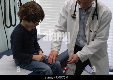 Young Asian male doctor examining Young boy du genou du patient dans une clinique Banque D'Images