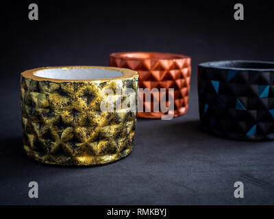 Couleur métallique béton géométrique moderne le semoir sur fond sombre. Béton peint des pots pour décoration de style minimaliste. Banque D'Images