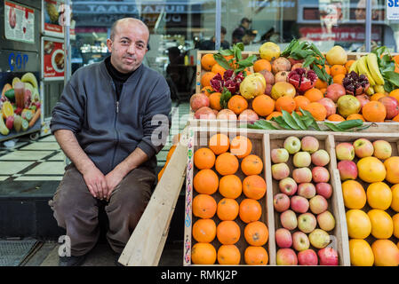 Un homme vend des pommes et des oranges, pamplemousses, dans des caisses en bois sur market stall .Istanbul,02,2019 Turkey-March Banque D'Images