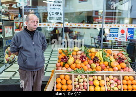 Un homme vend des pommes et des oranges, pamplemousses, dans des caisses en bois sur market stall .Istanbul,02,2019 Turkey-March Banque D'Images