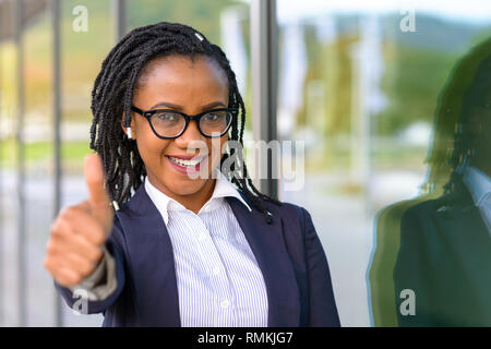 Portrait d'une élégante gaie African American Woman wearing glasses giving thumb up Banque D'Images