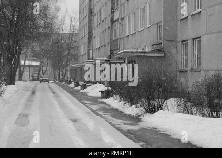 Les rues de la ville d'hiver avec les murs gris de l'immeuble en journée froide avec de la neige Banque D'Images