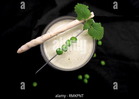 Soupe aux pois verts avec Grissini sur fond rustique foncé Banque D'Images