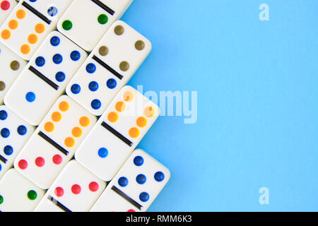 Dominos blancs avec des points colorés sur fond bleu shot passage with copy space Banque D'Images