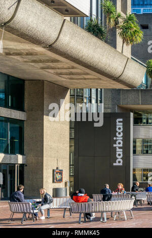 Les gens assis dehors le Barbican Arts Centre de Londres. Banque D'Images