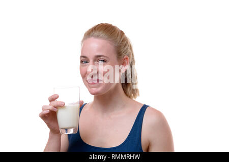 Portrait Portrait d'une belle et saine Jeune femme tenant un verre de lait tout en souriant et à la caméra à contre fond blanc pour c Banque D'Images