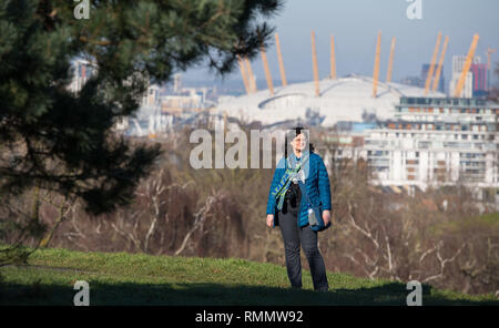 Une femme marche dans le soleil dans le parc de Greenwich, Londres du sud. Les prévisionnistes ont prédit une autre journée de beau temps le vendredi après le temps anormalement doux pour la saison a vu le jour de la Saint-Valentin plus chaude en plus de 20 ans, jeudi, avec un maximum de 16.1C (61F) enregistré dans la ville galloise de Bala, Gwynedd. Banque D'Images