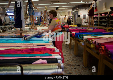Assistant-boutique avec rouleau de tissu, tissus Reine, 3-5, Place St Pierre, Montmartre, 75018 Paris, France Banque D'Images