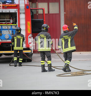 Vicenza, VI, Italie - 10 mai 2018 : trois pompiers italien et le camion de pompiers avec texte et uniforme Vigili del fuoco signifie que les pompiers en italien Banque D'Images