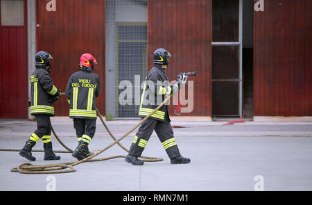 Italia, IT, Italie - 10 mai 2018 : trois pompiers italiens à la caserne avec unifiorm et texte Vigili del fuoco signifie que les pompiers en italien Lang Banque D'Images