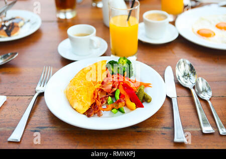 Omelette aux poivrons, concombre, bakon et salade sur la table à l'extérieur Banque D'Images