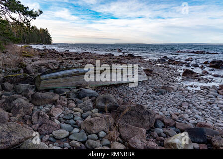 Old Grey bateau à rames à l'envers sur une plage rocheuse en Suède januari 2019 Banque D'Images