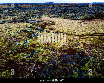 Femme debout dans les champs de lave verte dans le sud de l'Islande vue aérienne Banque D'Images