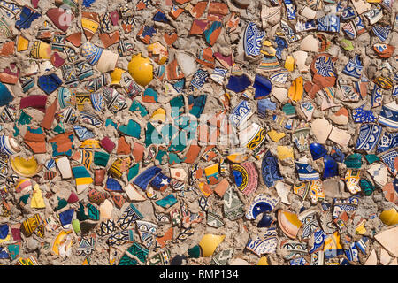 Des éclats colorés de fleurs ornementales, de céramique traditionnelle réutilisés après la rupture d'un mur à l'extérieur. Safi, Maroc. Banque D'Images