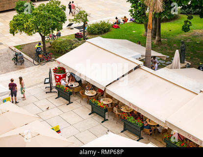 Les personnes mangeant à la chaussée en plein air, des tables de restaurant El Pimpi, vieille ville de Malaga, Andalousie, Espagne Banque D'Images