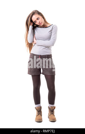 Jeune femme élégante triste déçu avec de longs cheveux et de pensée à la recherche vers le bas. Corps plein isolé sur fond blanc. Banque D'Images