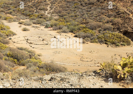 Les cercles de pierres formant un mandala de fleurs sur le sol à proximité d'un campement hippy à El Puertito, Tenerife, Canaries, Espagne Banque D'Images