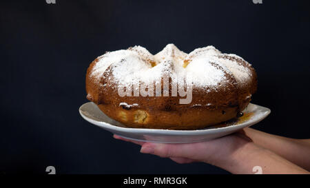 Cupcake avec de la poudre blanche dans les mains d'une femme Banque D'Images