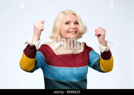 Granny gai avec sourire à pleines dents mains soulevées et montrant des signes de succès Banque D'Images