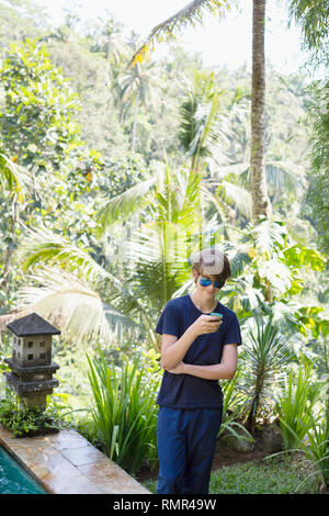 Teenage boy using cell phone Banque D'Images