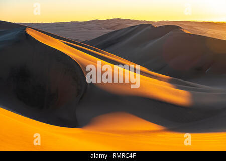 Coucher de soleil dans les dunes de sable et de désert entre l'Ica et, Huacachina Pérou, Amérique du Sud. Banque D'Images