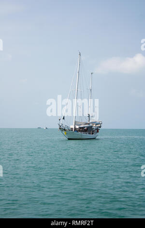 Voilier blanc nager dans la mer près de la côte de l'île de Ko Samui, Thaïlande Banque D'Images