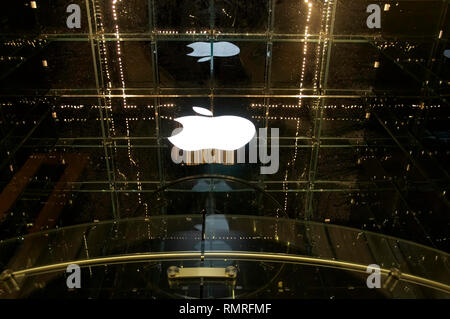 Le logo blanc d'Apple à un magasin phare à New York City's 5th Avenue la nuit. Banque D'Images
