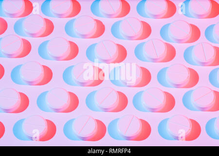 Pilules blanches avec effet de couleur sur un fond blanc dans les lignes. Banque D'Images